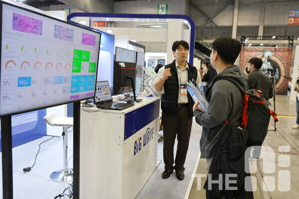 ‘THE AI SHOW 2024(TAS 2024)’광주정보문화산업진흥원 애그테크관 빅웨이브에이아이 부스에서 선보인 AI 작물 생육 예측 기반 유리온실 자율재배 시스템에 대한 설명을 듣고 있는 한 관람객. /구아현 기자