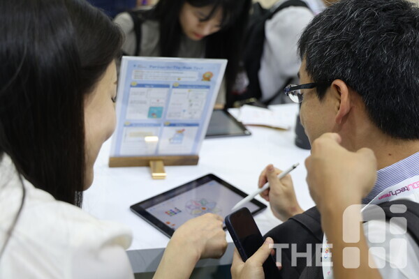 ‘에듀테크 아시아(Edutech Asia) 2024’에 참여한 아이스크림아트부스 ‘아트봉봉’ 체험관에서 한 관람객이 AI 그림 심리검사에 열중하고 있다. /구아현 기자