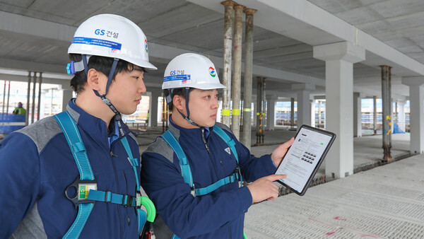 GS건설 관계자들이 GS건설이 개발한 AI기반 공사 매뉴얼 ‘자이북’을 현장에서 사용하고 있다. /GS건설