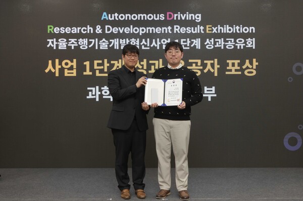지난 4일 일산킨텍스에서 열린 ‘자율주행기술개발혁신사업’ 1단계 성과공유회에서 카카오모빌리티 홍승환 책임연구원(오른쪽)이 수상 후 과학기술정보통신부 송창종 디바이스AX혁신팀장(왼쪽)과 기념사진을 촬영하고 있다. /카카오모빌리티