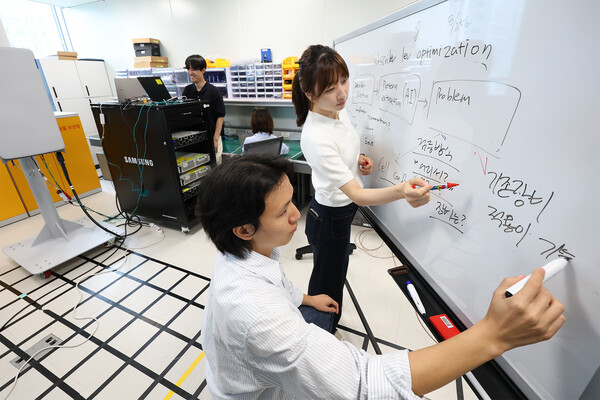 KT-삼성리서치 공동 연구팀이 무선망 최적화 기술 개발을 논의하는 모습. /KT