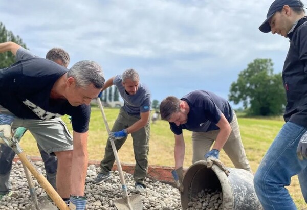 트랙터가 고장 나자 세일즈포스 직원들이 직접 나서 거대한 돌무더기를 옮기는 모습. /세일즈포스