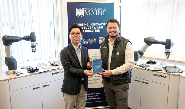 김현수 두산로보틱스 상무(왼쪽)가 브래들리 덴홀름(Bradley Denholm) 메인대학교 첨단제조센터 부소장과 기념사진을 촬영하고 있다. /두산로보틱스