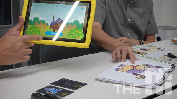 미니게이트가 자체 개발한 메타버스 기반 교육 플랫폼 위티버스 사용 모습. 디지털 패드로 사진을 찍으면 스케치북에 있는 캐릭터가 메타버스 가상현실에서 구현돼 보인다. /구아현 기자