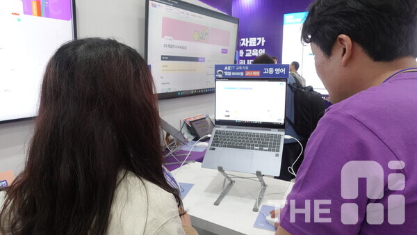 19일 열린 ‘에듀테크 코리아 페어 2025’ 전시관 ‘한국교과서협회공동관’ 부스에서 한 관람객이 YBM 고등 영어 AIDT 교육자료를 체험하고 있다. /구아현 기자